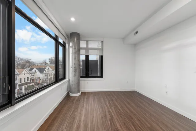 a view of hallway with a large window and wooden floor