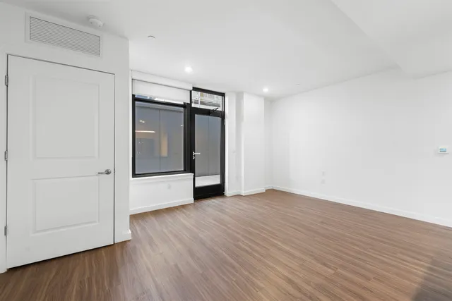 a view of an empty room with wooden floor