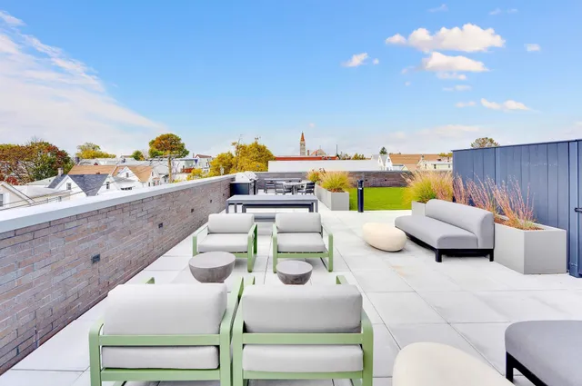 a view of a swimming pool with a couches chairs and potted plants