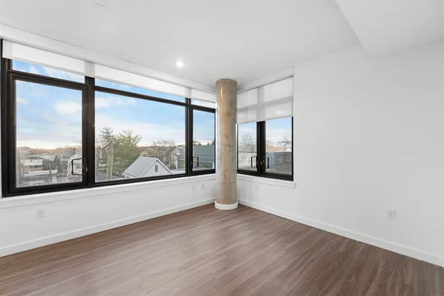 a view of a big room with wooden floor and windows