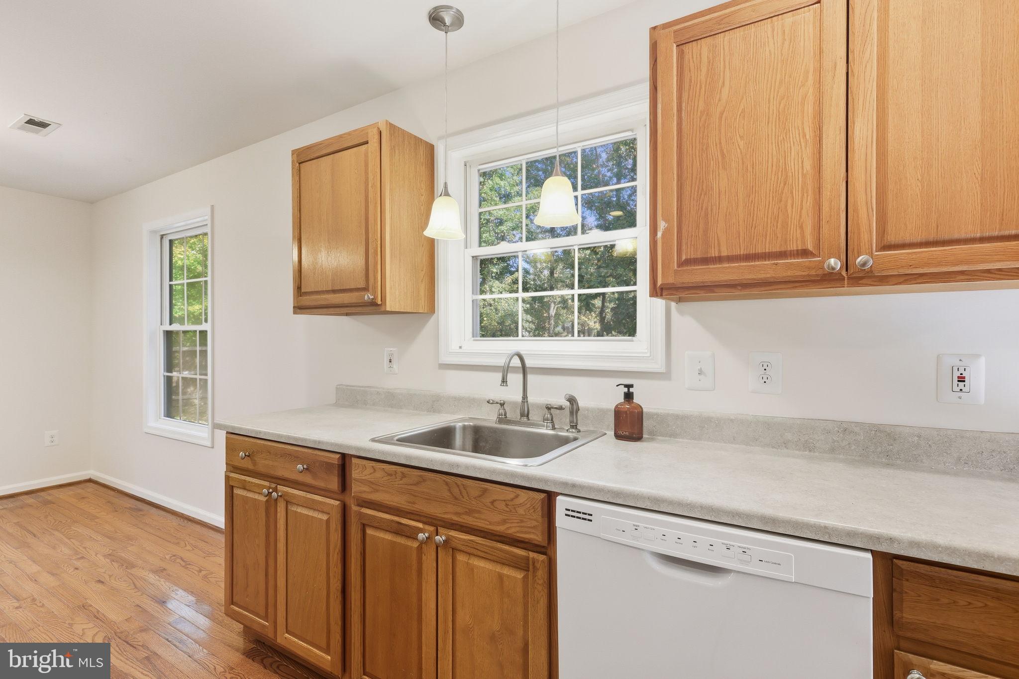 7168 Botha Road Bealeton, VA 22712 - Photo 15 of 36 a kitchen with stainless steel appliances granite countertop a sink and a white cabinets with wooden floor