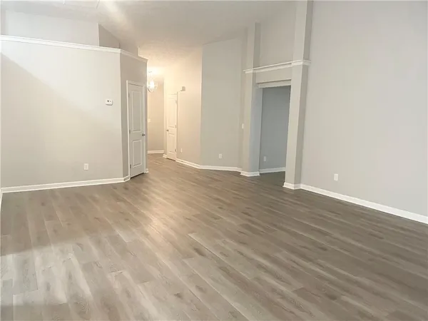 an empty room with wooden floor and mirror