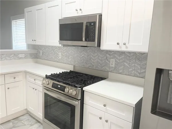 a kitchen with a refrigerator sink and cabinets