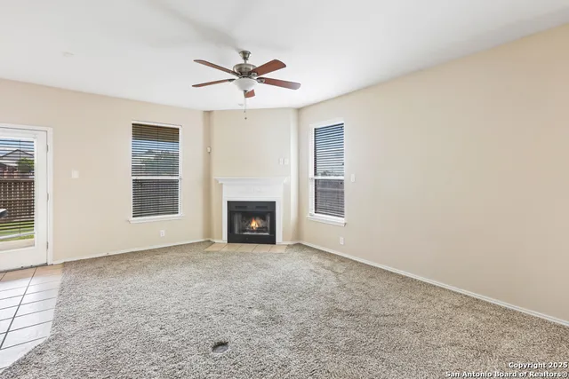 an empty room with windows and fireplace