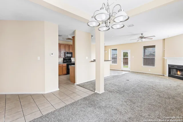 a view of an empty room with a fireplace and a window
