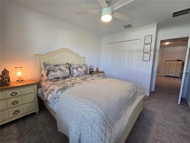 an empty room with closet and a ceiling fan