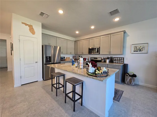a kitchen with stainless steel appliances granite countertop a refrigerator and a stove top oven