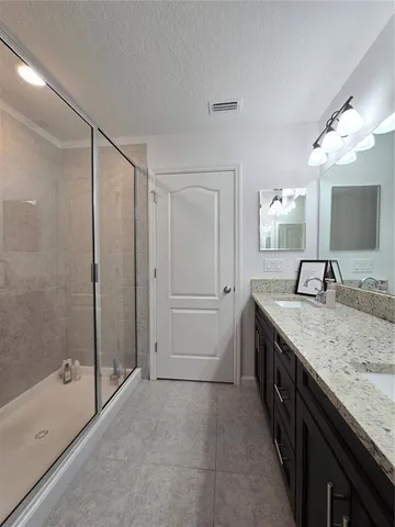 a bathroom with a granite countertop double vanity sink and a mirror