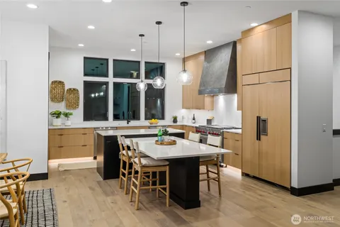 a kitchen with a refrigerator a stove a sink and chairs