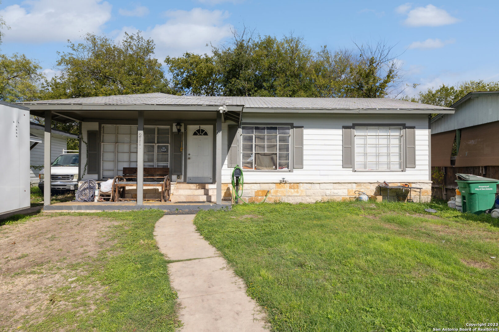 a front view of a house with a yard and potted plants