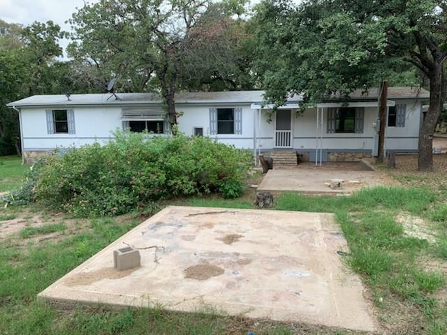 a front view of a house with garden and chairs