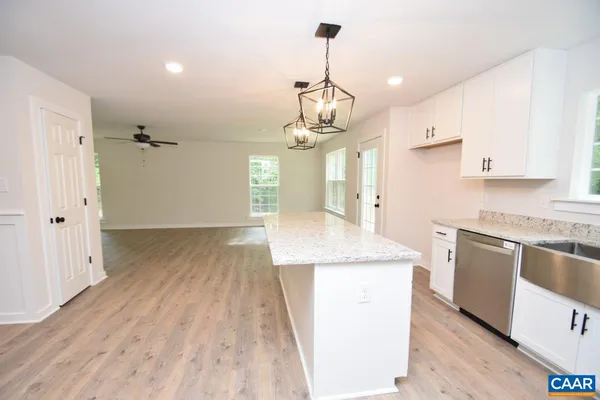 a kitchen with stainless steel appliances granite countertop hardwood floor sink stove and granite counter top