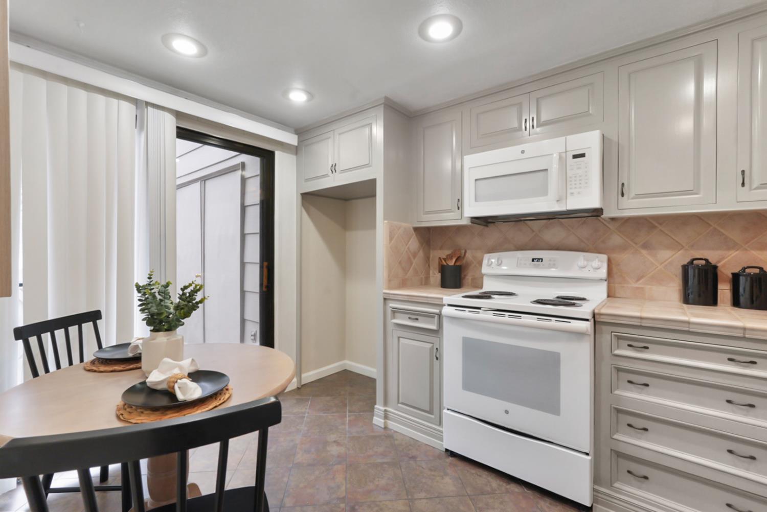 230 West Rumble Road, Unit B Modesto, CA 95350 - Photo 4 of 24 a kitchen with a stove and white cabinets