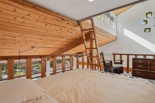 a large bedroom with a bed and large windows