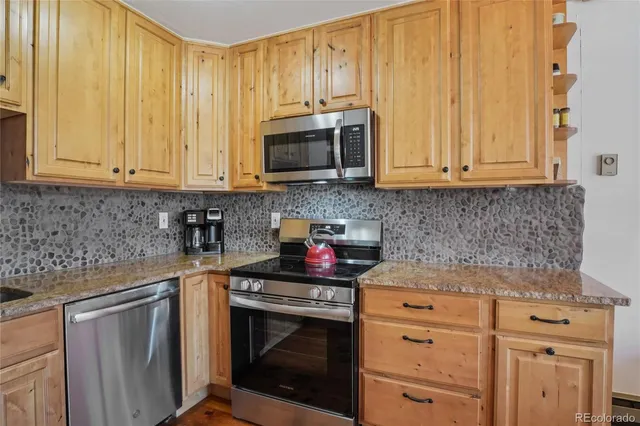 a kitchen with stainless steel appliances white cabinets and a stove top oven