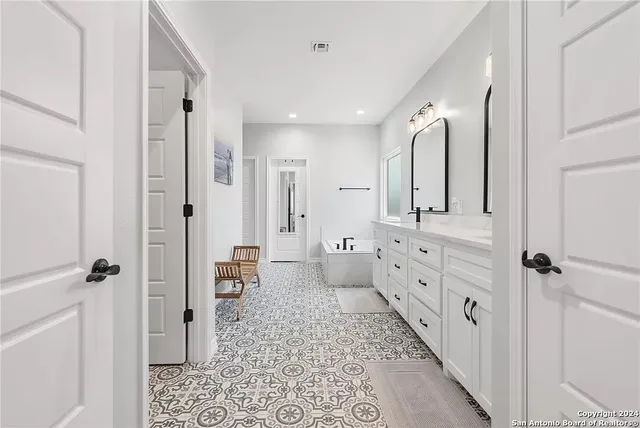 a bathroom with a double vanity sink a toilet a mirror and shower