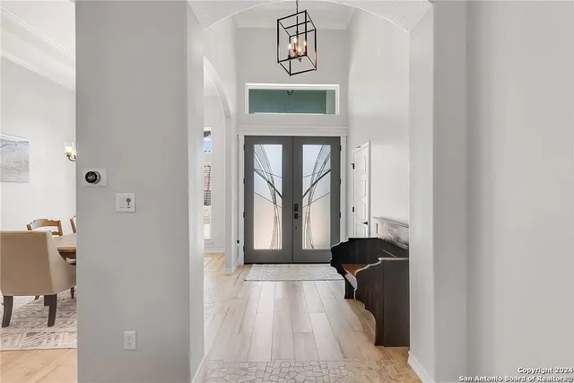 a view of a hallway with windows and chandelier