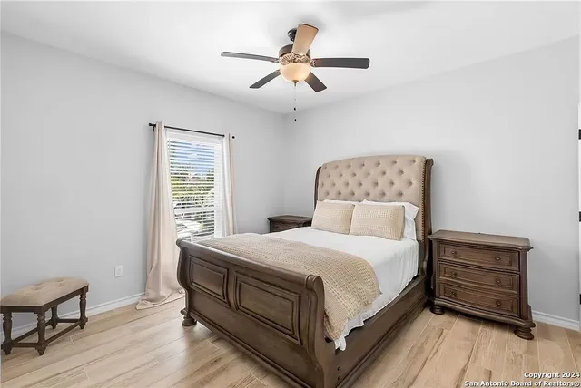 a bedroom with a bed and a ceiling fan