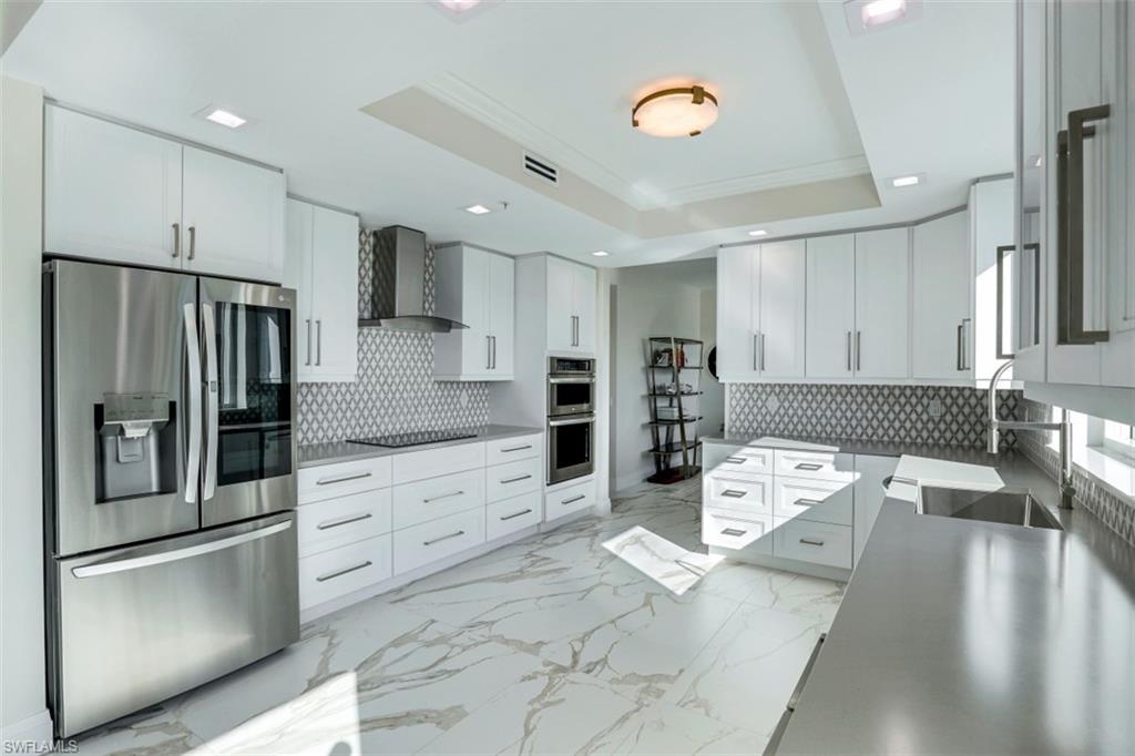 425 Cove Tower Drive, Unit 301 Naples, FL 34110 - Photo 12 of 43 a living room with stainless steel appliances kitchen island granite countertop furniture a refrigerator and a sink