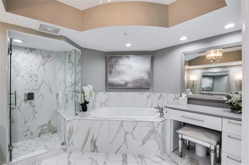 425 Cove Tower Drive, Unit 301 Naples, FL 34110 - Photo 20 of 43 a spacious bathroom with a double vanity sink a large mirror and shower
