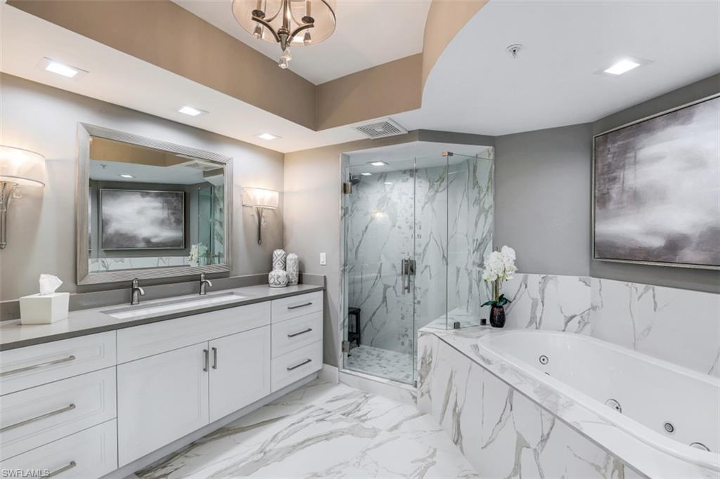 425 Cove Tower Drive, Unit 301 Naples, FL 34110 - Photo 21 of 43 a bathroom with a double vanity sink mirror double and bathtub