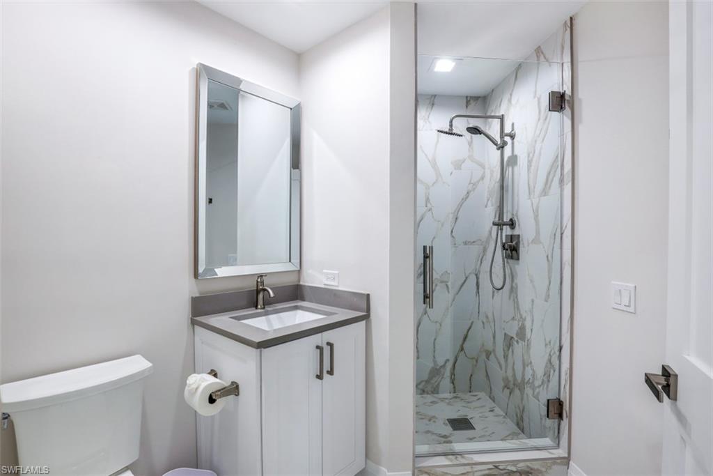 425 Cove Tower Drive, Unit 301 Naples, FL 34110 - Photo 23 of 43 a bathroom with a granite countertop sink toilet and shower
