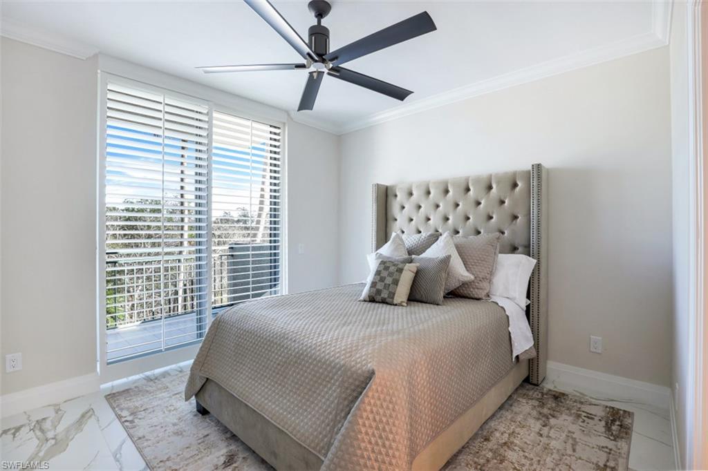425 Cove Tower Drive, Unit 301 Naples, FL 34110 - Photo 24 of 43 a bedroom with a bed and wooden floor