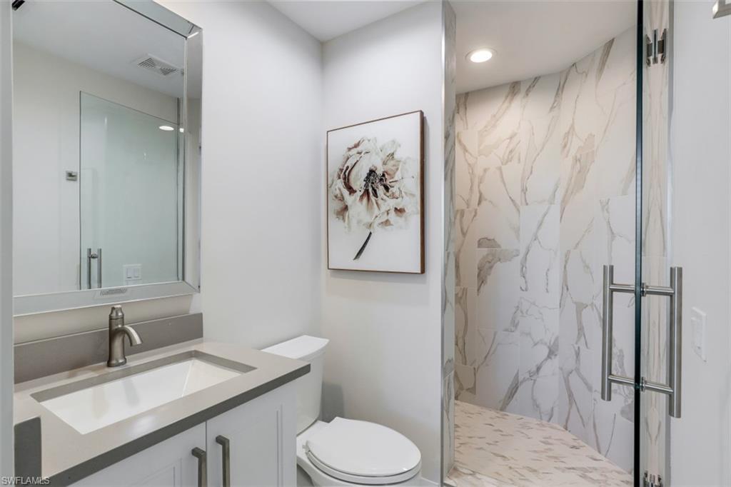 425 Cove Tower Drive, Unit 301 Naples, FL 34110 - Photo 25 of 43 a bathroom with a granite countertop sink toilet and shower