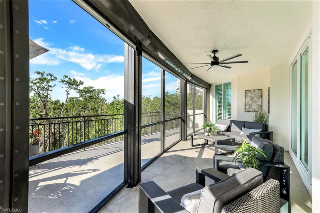 425 Cove Tower Drive, Unit 301 Naples, FL 34110 - Photo 28 of 43 a living room with furniture and a floor to ceiling window