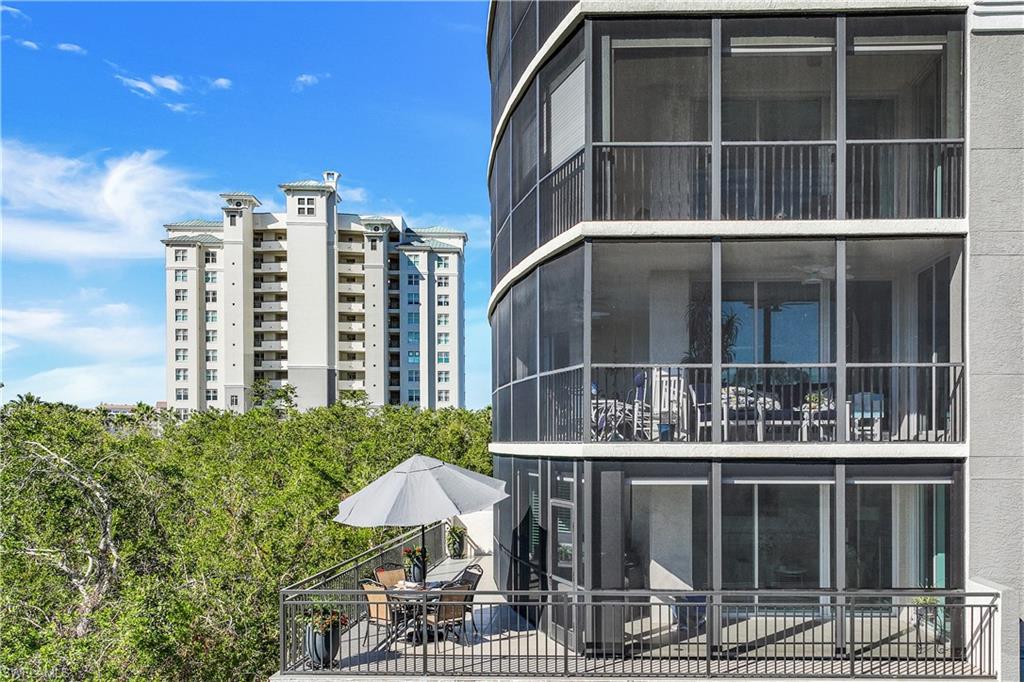 425 Cove Tower Drive, Unit 301 Naples, FL 34110 - Photo 30 of 43 a couple of table and chairs under an umbrella