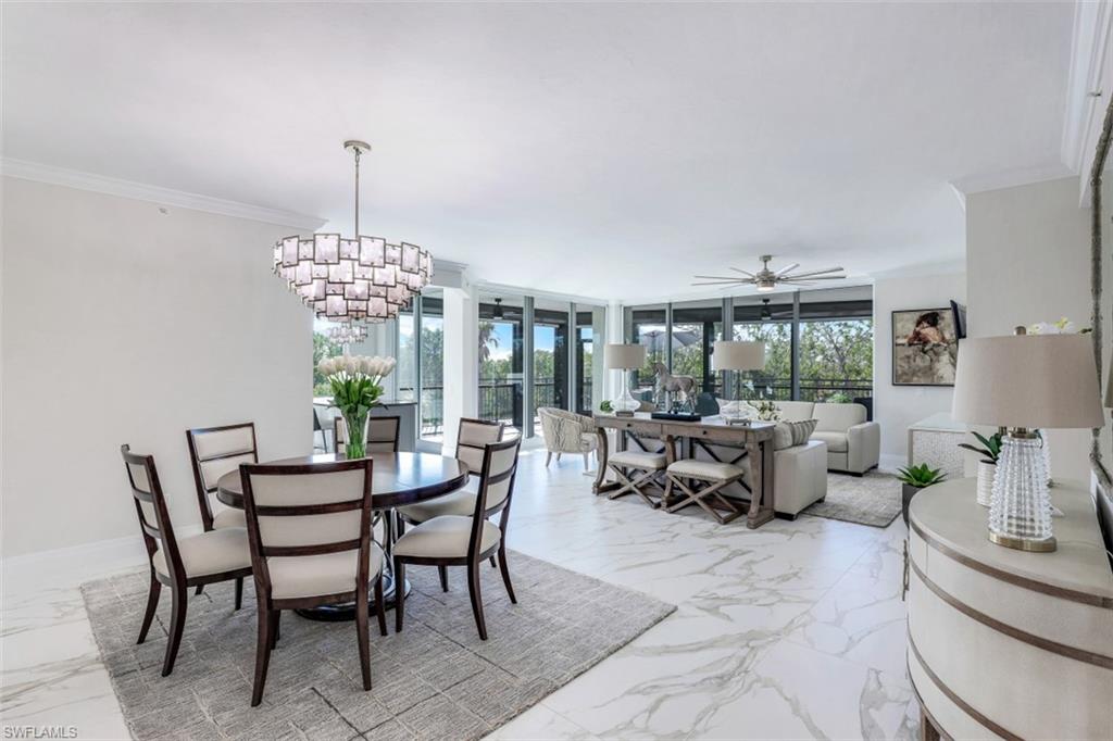 425 Cove Tower Drive, Unit 301 Naples, FL 34110 - Photo 4 of 43 a view of a dining room with furniture a livingroom and chandelier