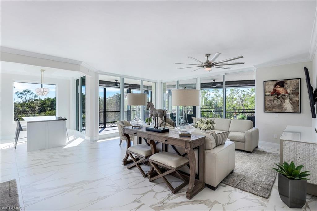 425 Cove Tower Drive, Unit 301 Naples, FL 34110 - Photo 5 of 43 a living room with furniture and a large window