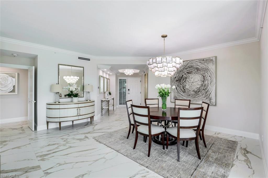 425 Cove Tower Drive, Unit 301 Naples, FL 34110 - Photo 6 of 43 a view of a dining room with furniture and chandelier