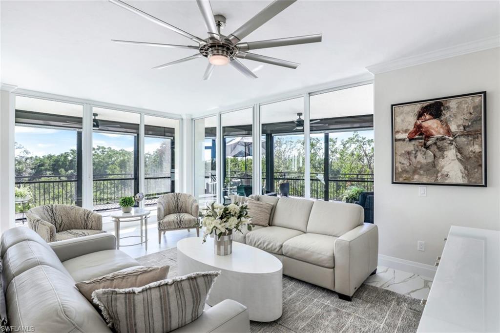 425 Cove Tower Drive, Unit 301 Naples, FL 34110 - Photo 7 of 43 a living room with furniture and a large window with garden view