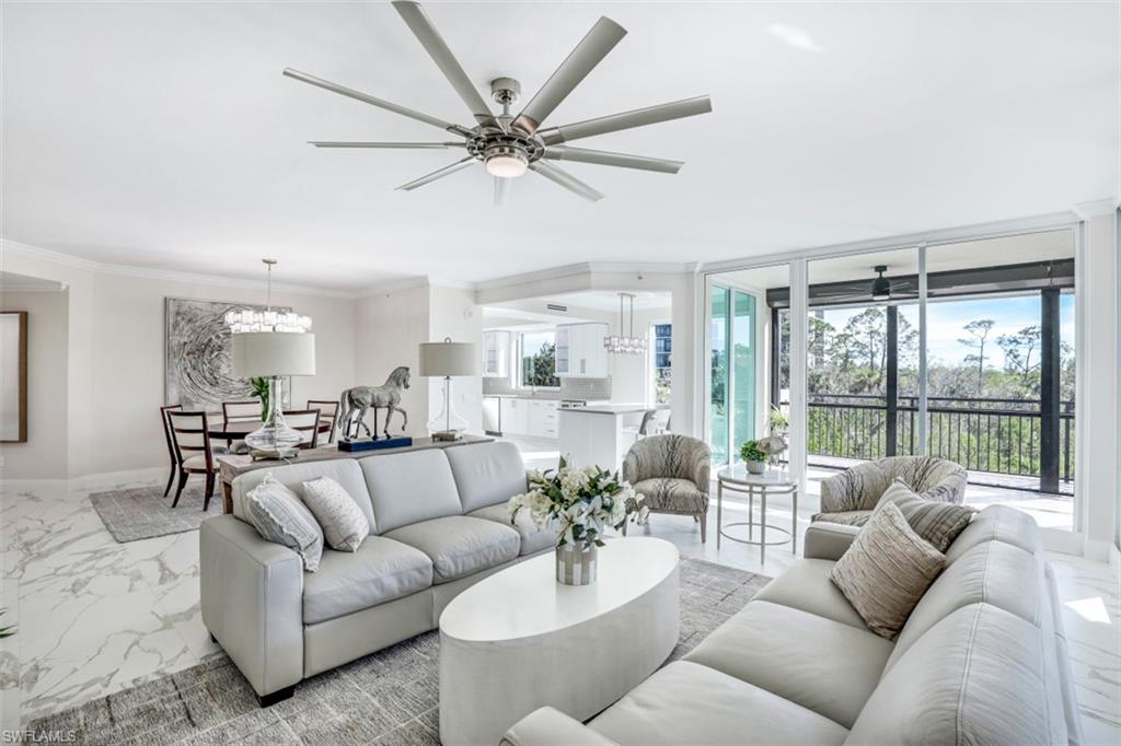 425 Cove Tower Drive, Unit 301 Naples, FL 34110 - Photo 8 of 43 a living room with furniture and a large window