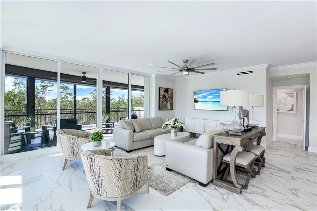 425 Cove Tower Drive, Unit 301 Naples, FL 34110 - Photo 9 of 43 a living room with furniture and a large window