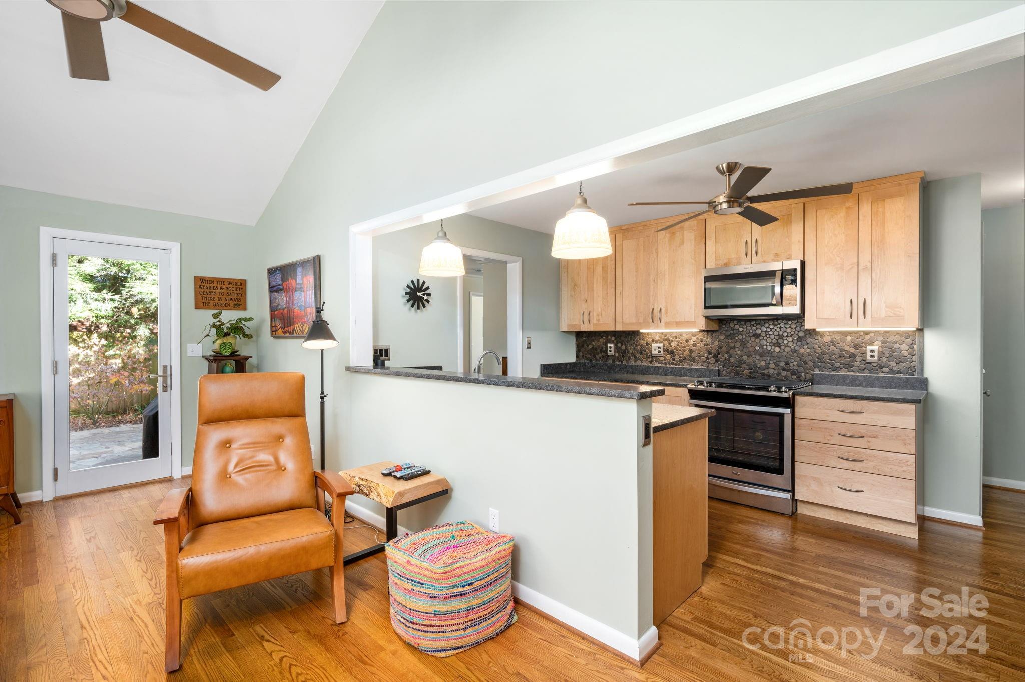 24 Maplewood Road Asheville, NC 28804 - Photo 12 of 38 a large living room with stainless steel appliances kitchen island granite countertop furniture and a wooden floor