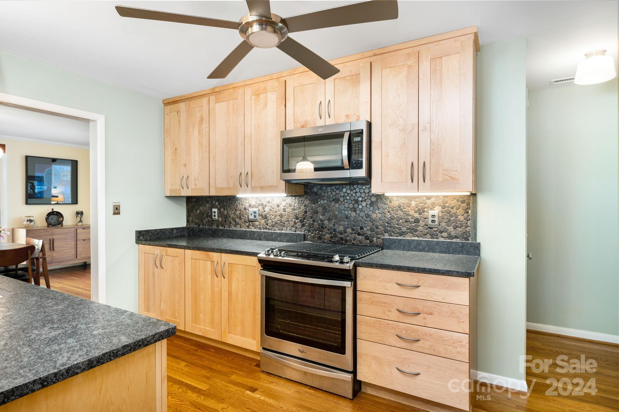 24 Maplewood Road Asheville, NC 28804 - Photo 10 of 38 a kitchen with stainless steel appliances granite countertop a stove microwave and cabinets