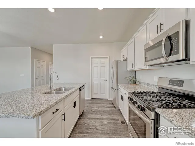 a kitchen with stainless steel appliances granite countertop a stove a sink and a microwave