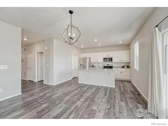 a view of a kitchen with wooden floor and window