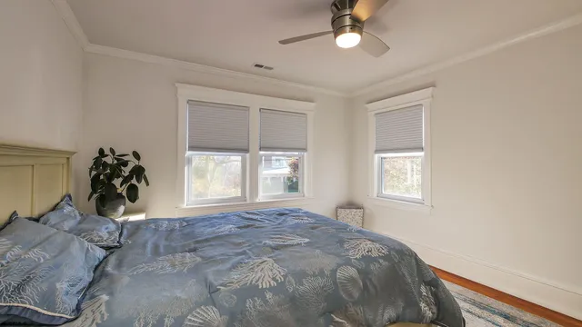 a bed sitting in a bedroom next to a window and a mirror