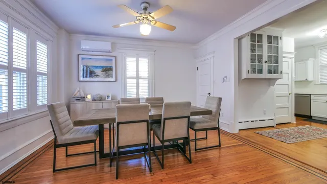 a view of a dining room with furniture a rug and wooden floor