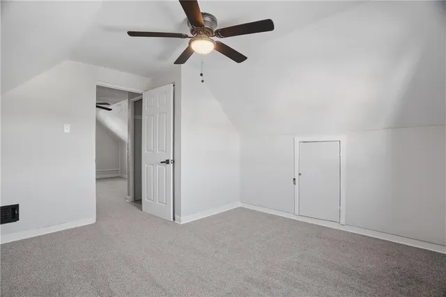 an empty room with closet and a chandelier fan