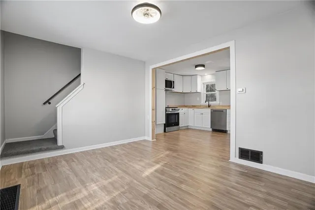 a view of a kitchen with wooden floor and cabinets