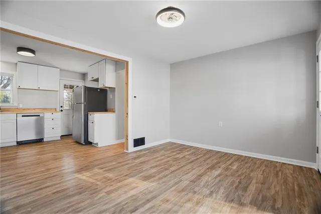 a view of a kitchen with a sink refrigerator and wooden cabinets