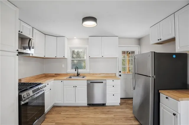 a kitchen with white cabinets and refrigerator