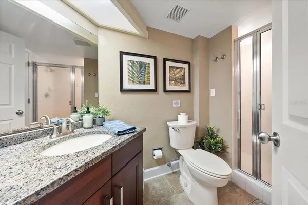 a bathroom with a granite countertop sink mirror vanity and toilet