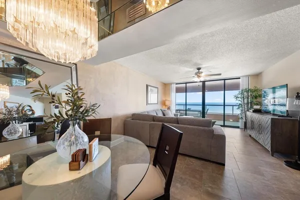 a living room with furniture large window and wooden floor