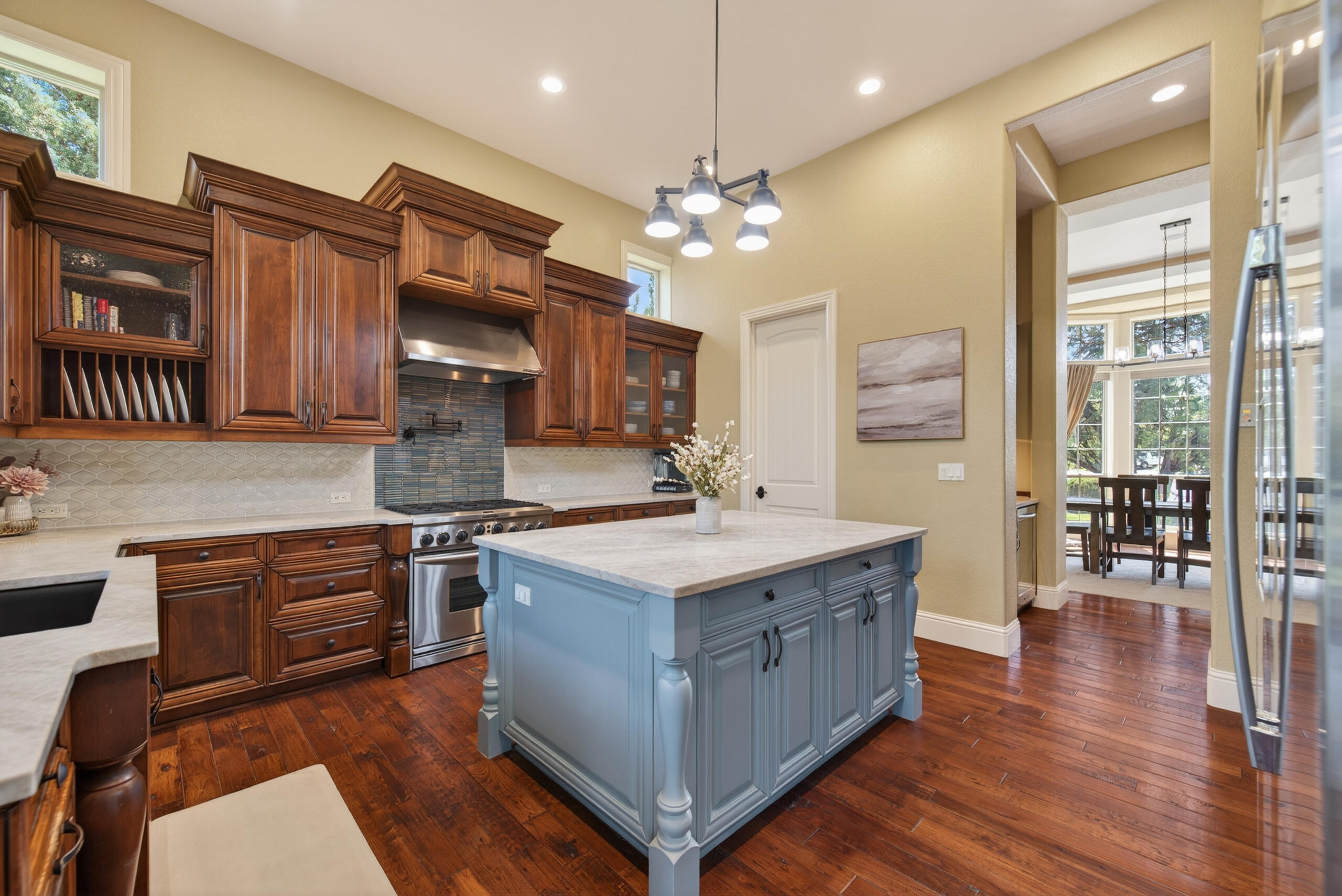 9009 Merlin Drive Redmond, OR 97756 - Photo 17 of 98 a kitchen with stainless steel appliances granite countertop a sink stove and wooden cabinets