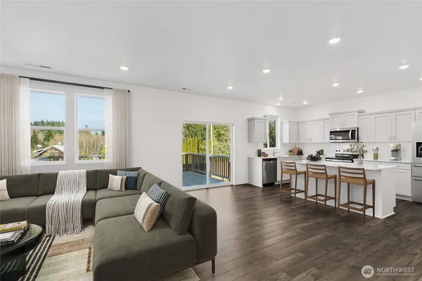 a living room with stainless steel appliances furniture and a large window